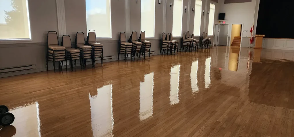 Banquet hall hardwood floor polished to a mirror shine under the stage