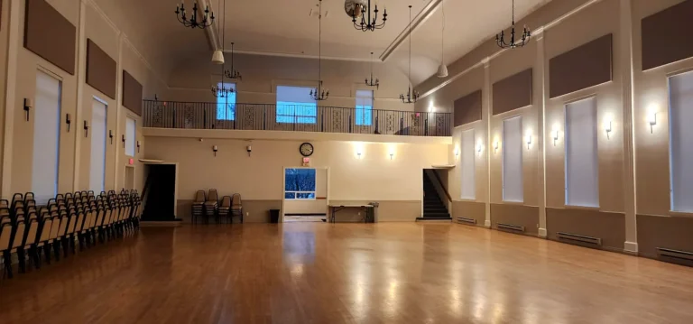 Large church hall with a polished hardwood floor and a balcony