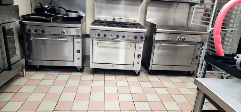 Church kitchen with gas ranges and a pink and grey tile floor