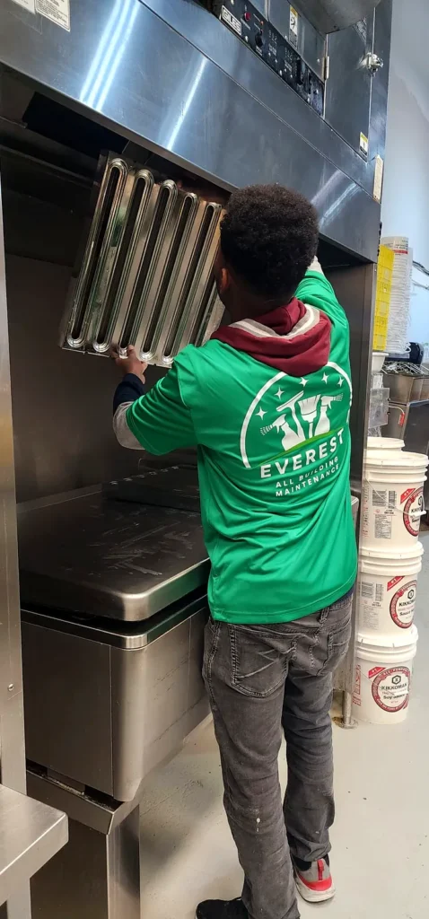 Everest crew member removing a baffle filter from a kitchen exhaust hood