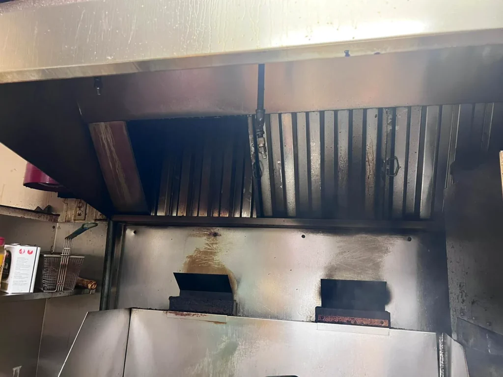 Before: kitchen exhaust hood with grease stains on the stainless steel