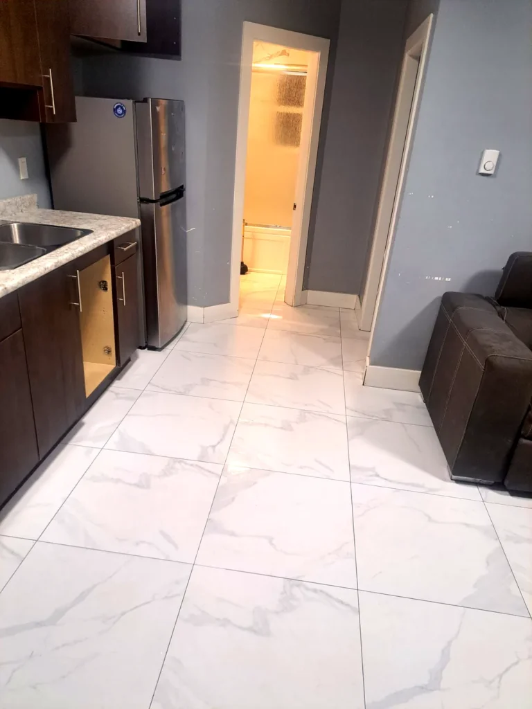 Clean glossy tile floor running through an apartment kitchen