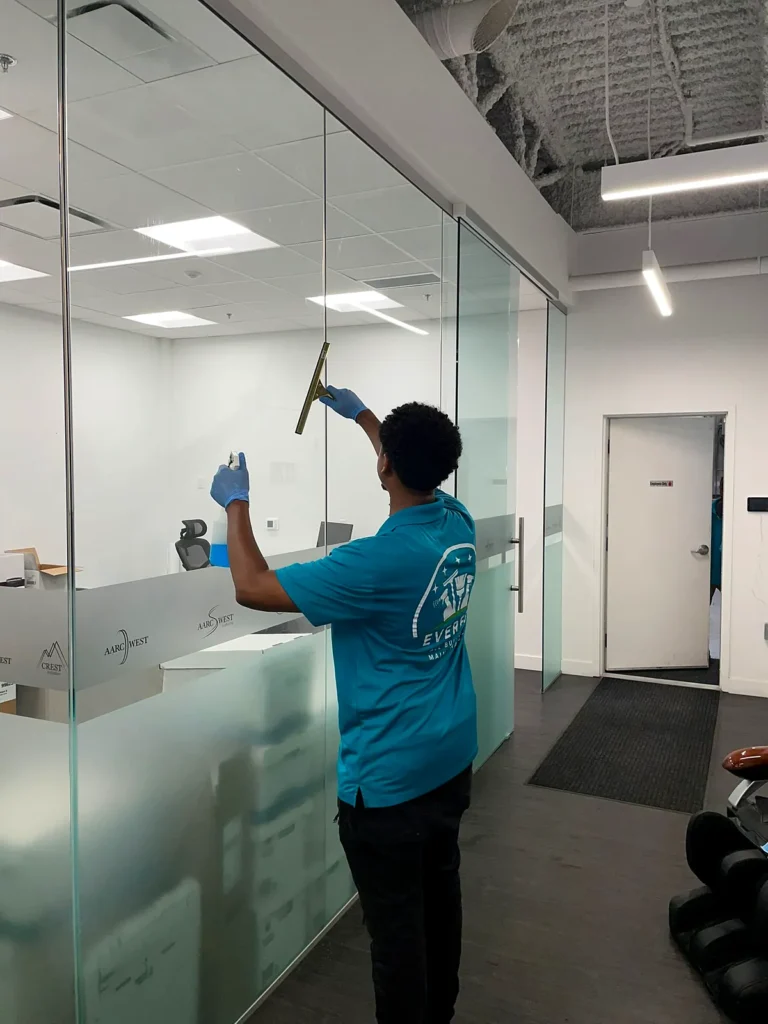 Everest crew member squeegeeing a glass partition in an open office