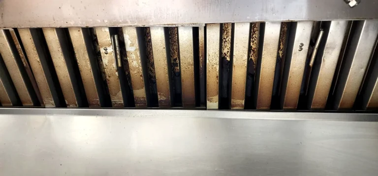 Baffle filters inside a restaurant exhaust hood with visible grease build-up
