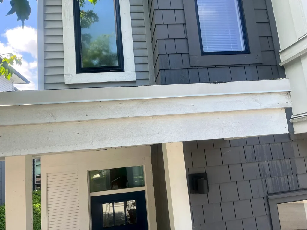 After: clean white soffit and siding above a townhouse entrance