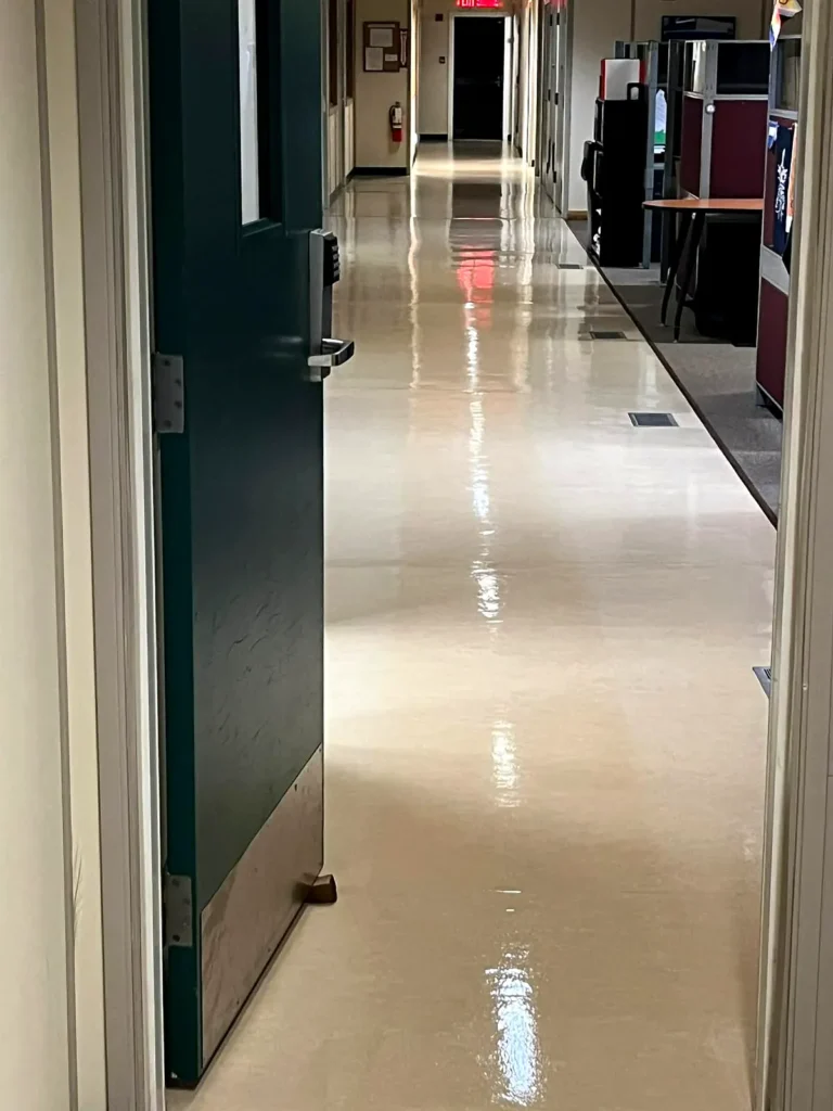 Glossy waxed vinyl corridor floor beside a green door