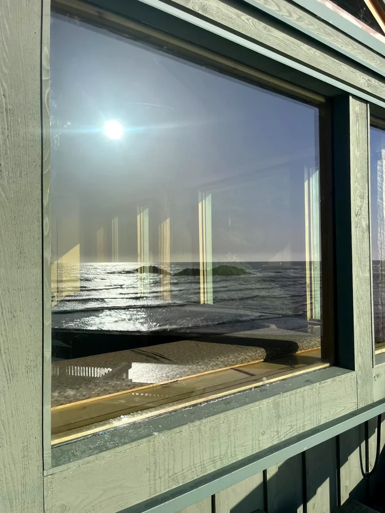 Clean window glass reflecting the sun and the sea